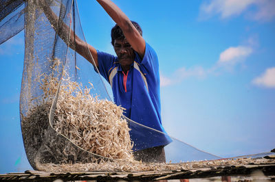 Fisherman releasing fish on roof for drying