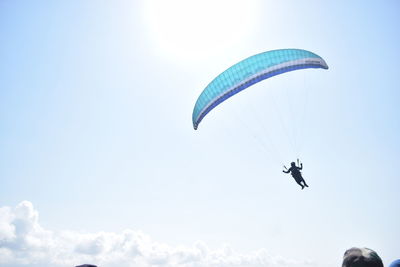 Low angle view of person paragliding against sky