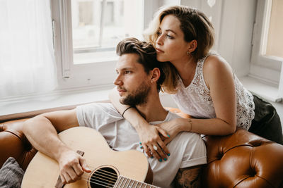 Young couple sitting on sofa at home