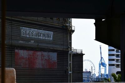 Information sign in city against sky