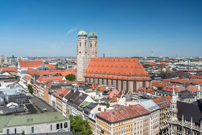 Aerial view of townscape against blue sky