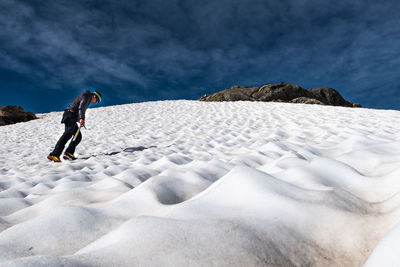 Full length of man on snowcapped mountain against sky