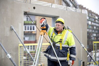 Engineer using theodolite at construction site