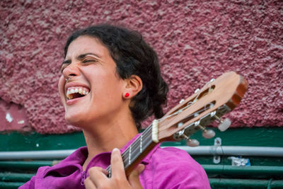 Woman screaming while playing guitar