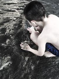 High angle view of shirtless man in sea