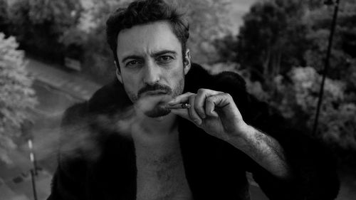 Portrait of young man smoking cigarette