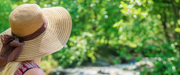 Close-up of woman wearing hat on rock