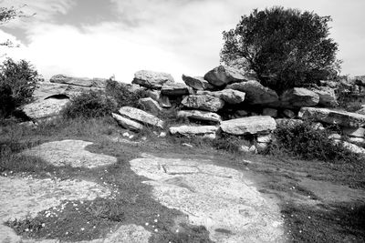 Rocks on landscape against sky