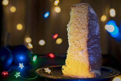 Close-up of cake on illuminated christmas lights