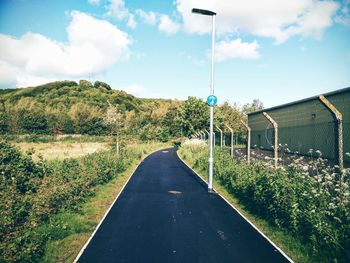 Empty road against cloudy sky