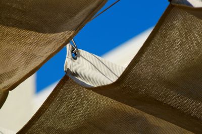 Close-up of clothes hanging against blue sky