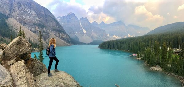 Woman in lake against mountains