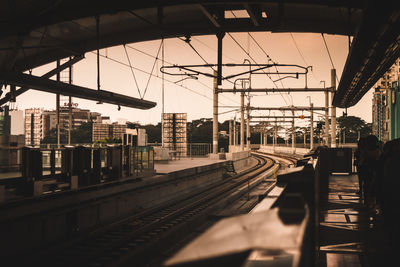 Train at railroad station in city against sky