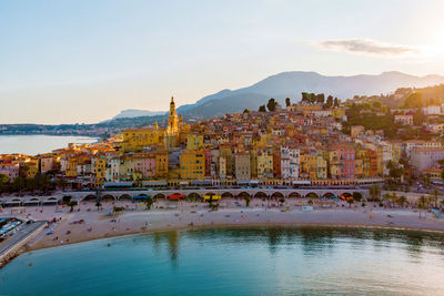 High angle view of townscape by sea against sky