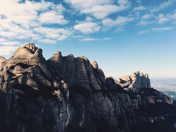 Rock formations on cliff against sky