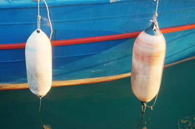 Buoy hanging over boat moored on sea