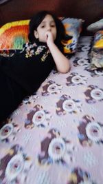 Portrait of girl lying on bed at home