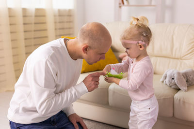 Side view of boy playing with daughter at home