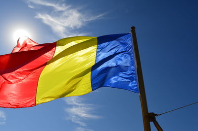 Low angle view of flag against blue sky