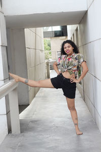 Full length of woman stretching in corridor