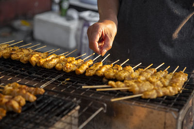 Person preparing food on barbecue grill