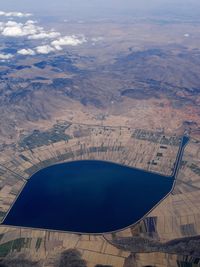 Aerial view of agricultural landscape against cloudy sky