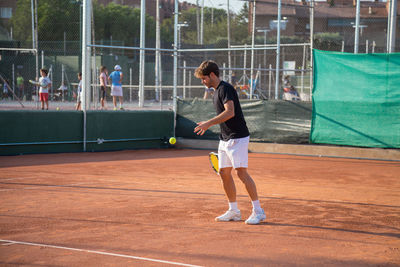 Young man playing tennis at court