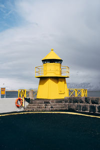 Built structure on road by sea against sky