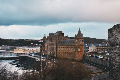 Arch bridge over river against buildings in city