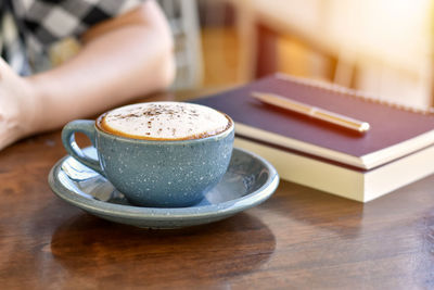 Midsection of woman using mobile phone on table