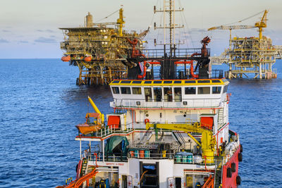 View of a n anchor handling tug boat with oil production platform on the background  at oil field