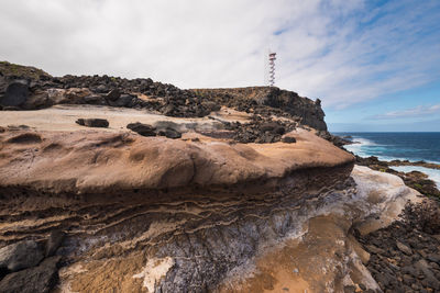 Scenic view of rocks on beach against sky