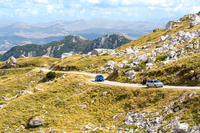 Rear view of man walking on mountain against sky
