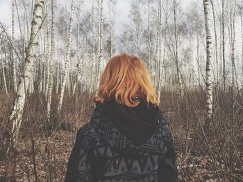 Rear view of woman standing at forest