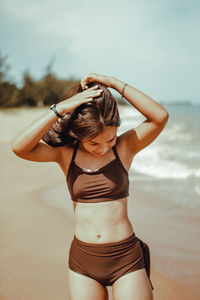 Rear view of woman standing at beach