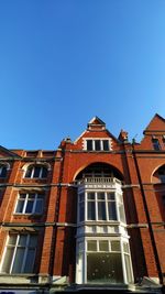 Low angle view of old building against clear blue sky