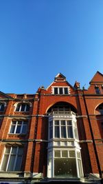 Low angle view of old building against clear blue sky