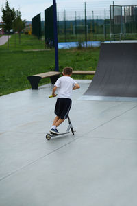 Low section of man skateboarding on road