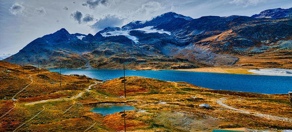 Scenic view of lake by mountains against sky