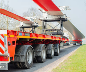 Red shopping cart on road against trees