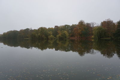 Reflection of trees in lake against clear sky