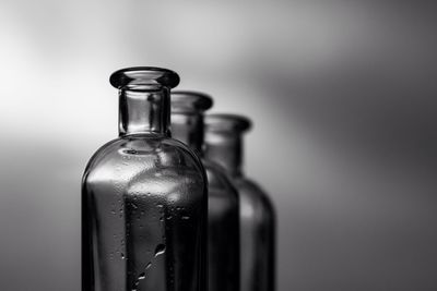 Close-up of three glass bottle against blurred background
