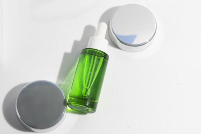 High angle view of pills and bottle against white background