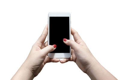 Cropped hands of woman using mobile phone against white background