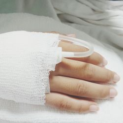 Cropped hand of woman with iv drip in hospital