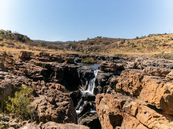 Scenic view of waterfall against clear sky