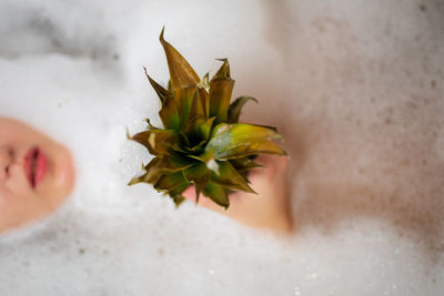 Midsection of woman holding pineapple while bathing