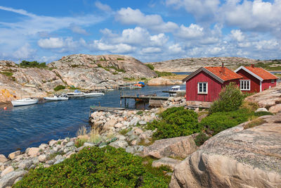 Houses by rocks and buildings against sky