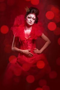 Portrait of young woman wearing red costume against defocused background