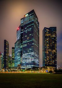 Illuminated buildings against clear sky at night